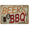 A rustic metal tin sign with the text BEERS & BBQ in distressed orange and red lettering.