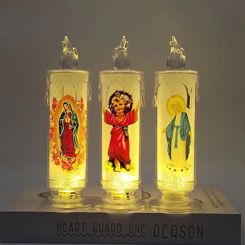 Three glass votive candles with glowing LED lights depicting religious figures on a dark background.