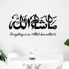 Black calligraphy art featuring the phrase 'Masha Allah' in Arabic and English on a white wall.