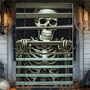 A window is covered by a banner featuring a skull and skeletal hands for a scary Halloween theme.