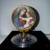 A round gold-framed painting depicting the Virgin Mary and the Christ Child.