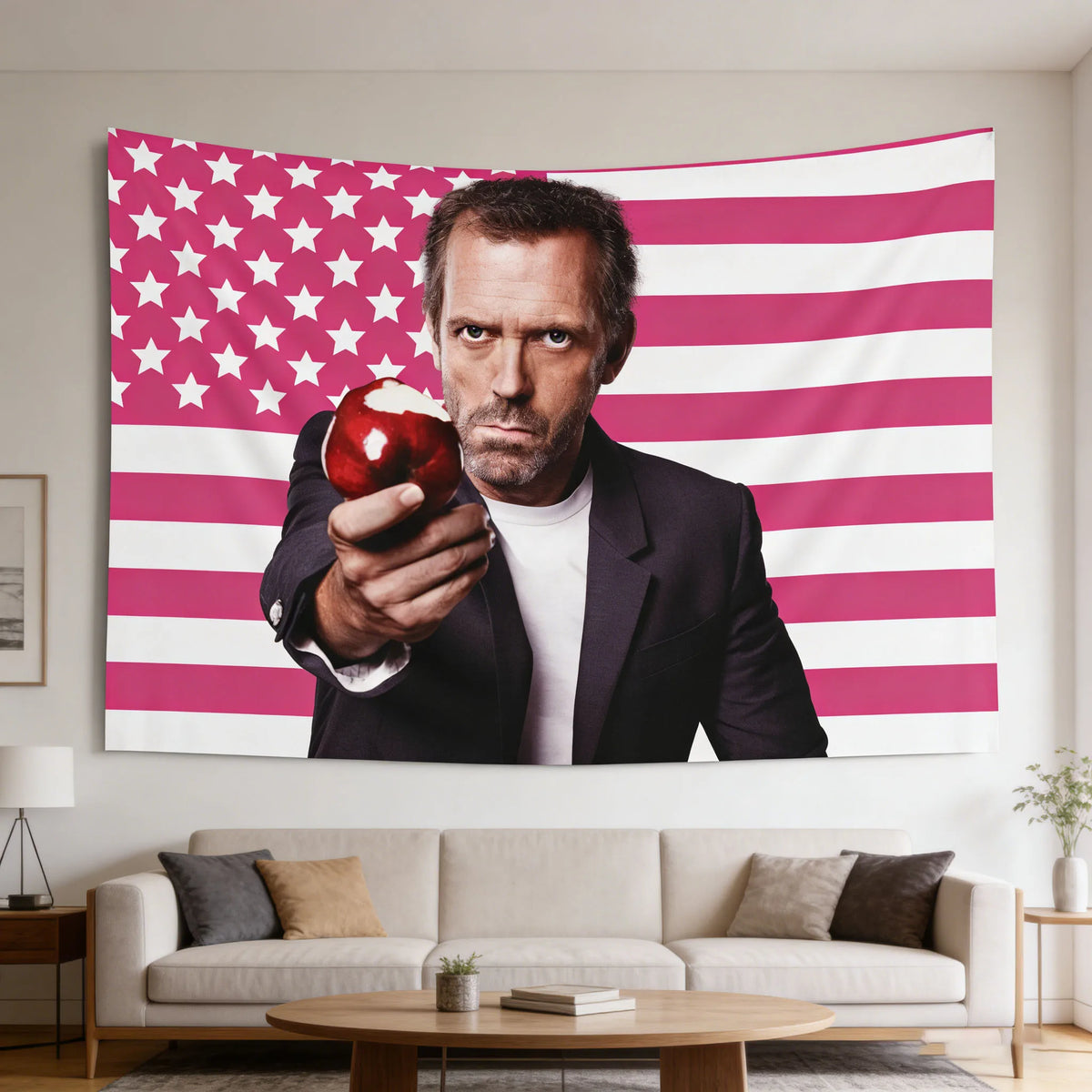 Un hombre de traje sostiene una manzana contra una tapicería de bandera estadounidense a rayas rosa y blanca.