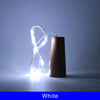 A glowing white LED wine bottle cork light is shown next to a brown bottle.
