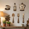 A collection of vintage wooden coffee utensils, including a grinder, fork, and spoon, displayed on a light-colored wall.