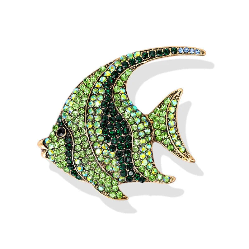 A vintage marine life brooch pin set shaped like a fish, encrusted with green and blue rhinestones.