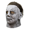 A realistic gray latex horror mask resembling Michael Myers with distressed skin and dark hair.