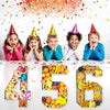 Fillable cardboard numbers 456 arranged in a party tray with colorful confetti and streamers