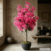 Leuchtend pinker künstlicher Bougainvillea-Baum in dunker Topf, innen vor strukturierter Wand