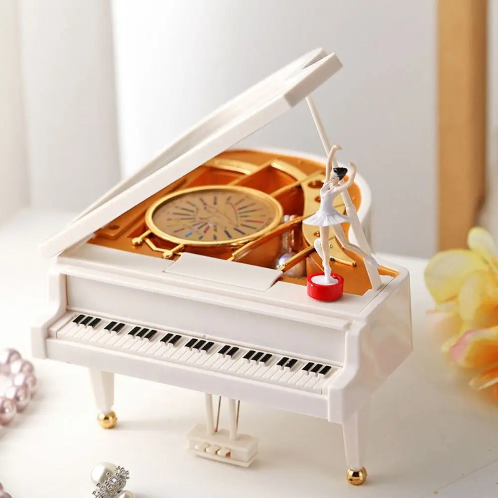 A white hand-crank music box featuring a ballerina with a spinning top inside.