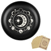 Assiette décorative noire avec motif céleste blanc : lune, étoiles et feuillage.