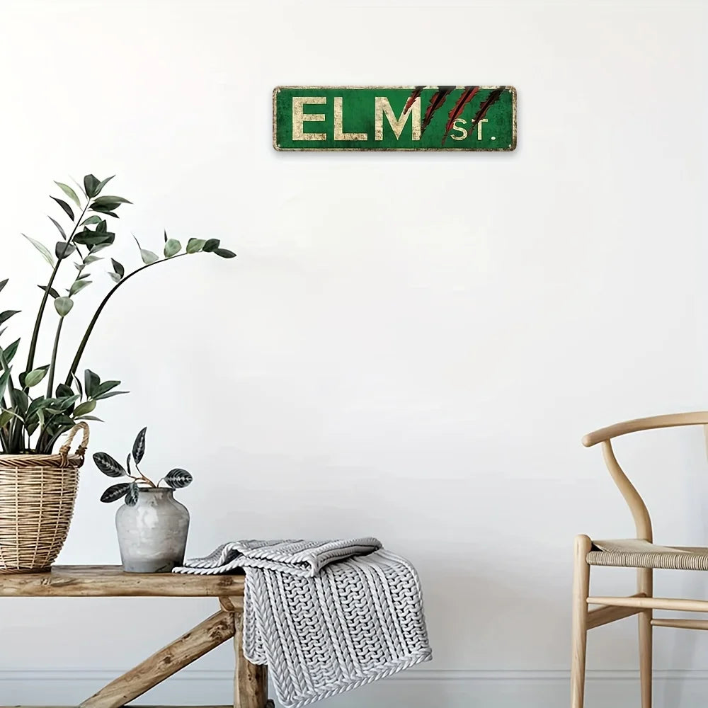 Panneau mural de film d'horreur rustique en métal avec le texte ELM sr. fixé sur un mur blanc.