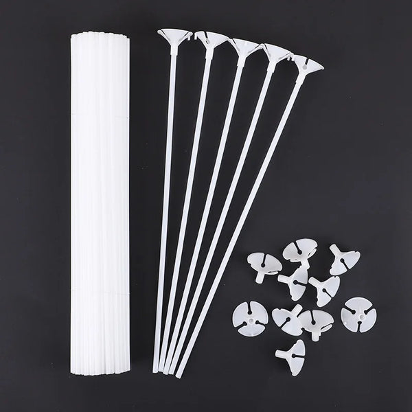 White macaron balloon sticks with holder cups arranged diagonally on a dark background