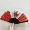 A handheld folding fan featuring a design of the Canadian flag in red and white.