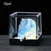 A clear display box shows a rough, translucent blue and white opal crystal specimen.