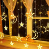 String lights shaped like stars and moons hanging in front of a window with an orange bird statue