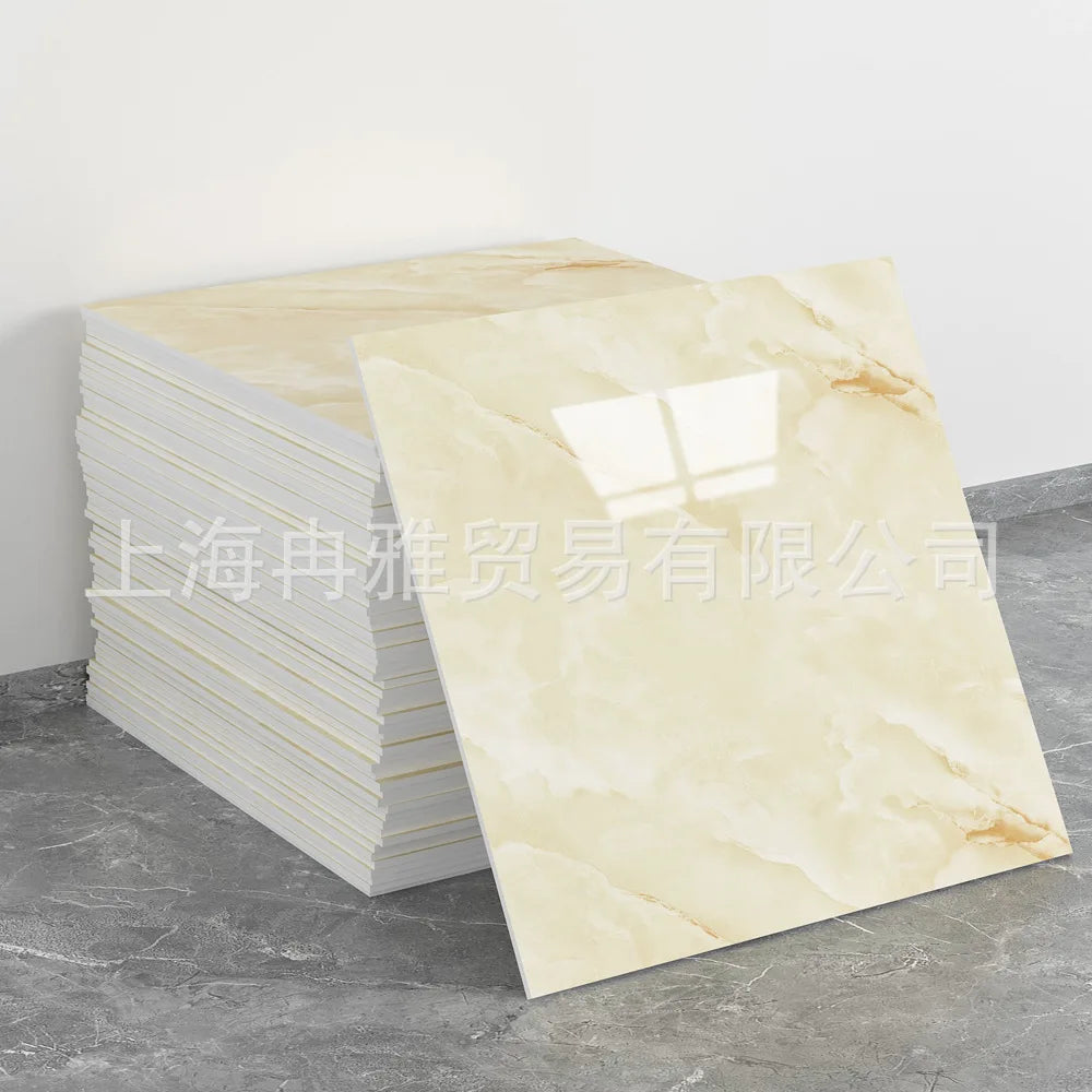 A rectangular slab of light beige marble-patterned stone tile displayed next to a stack of white tiles.
