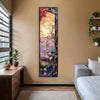 A vertical tapestry featuring a Bohemian Tree of Life design with vibrant floral and foliage colors hanging on a beige wall.