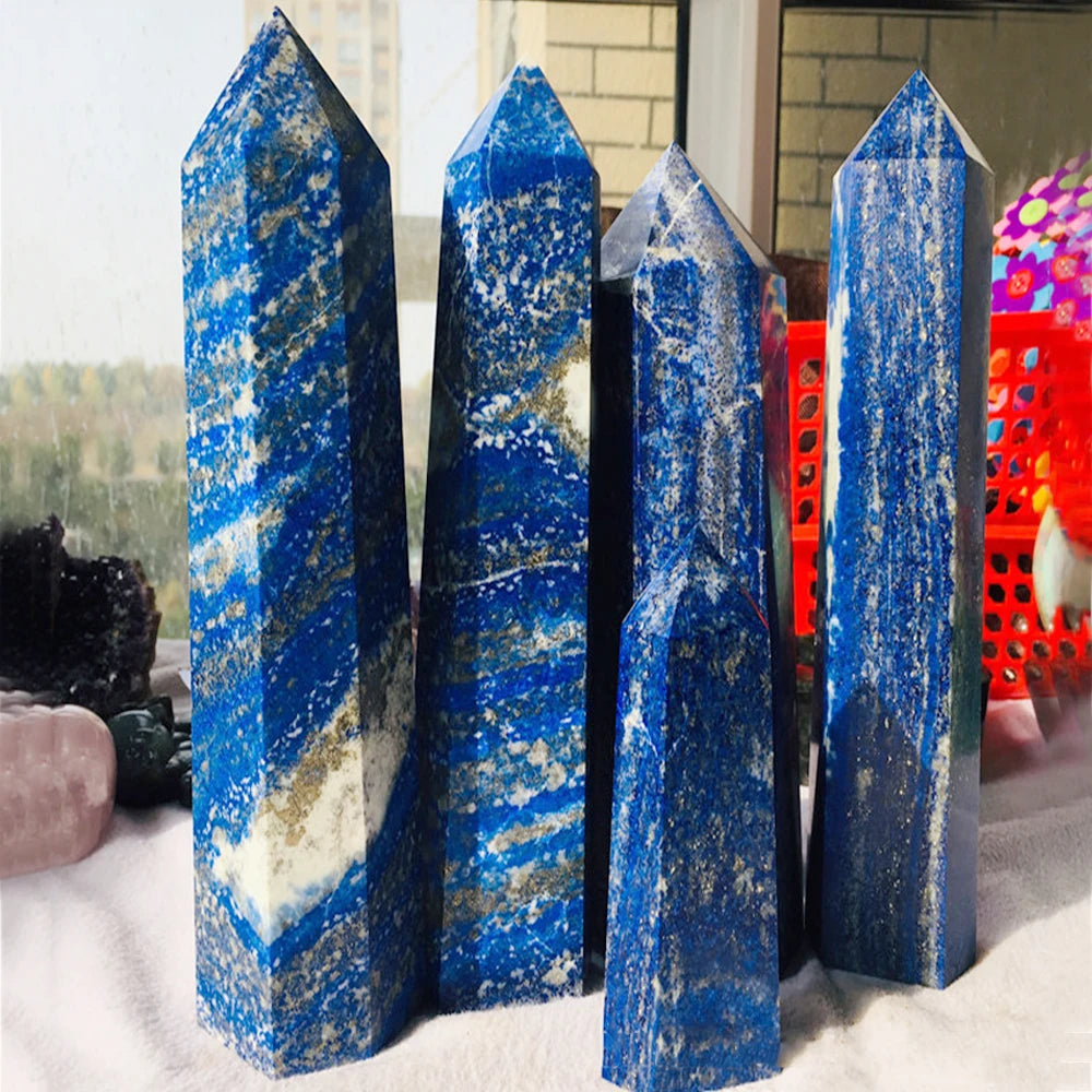 A collection of tall, polished blue lapis lazuli crystals displayed vertically for meditation and home decor.