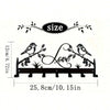 Black metal wall decor featuring a bird silhouette and decorative foliage, with dimensions 25.8cm or 10.15in.