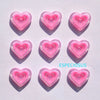 A set of pink heart-shaped acrylic charms arranged in a grid on a white background.