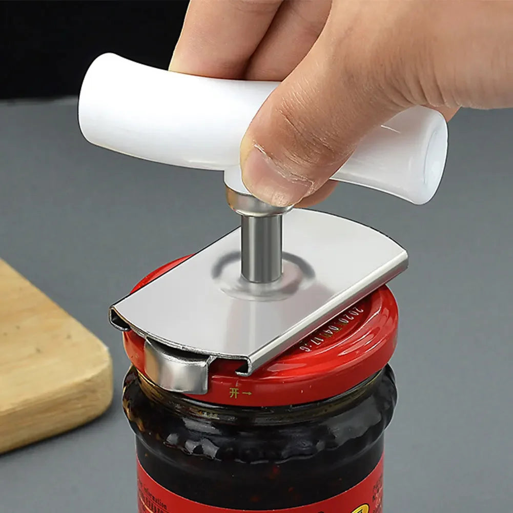 A hand is using a stainless steel multi-function bottle cap opener to open a glass jar.