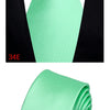 A bright mint green silk necktie tied in a four-in-hand knot against a black shirt collar.