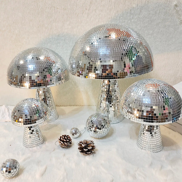 A display of mushroom-shaped disco ball decorations made of silver mosaic tiles.