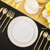 A set of gold rim plastic plates is displayed on a black surface with cutlery and a yellow napkin.