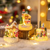 A set of three illuminated Christmas gingerbread house resin ornaments resting on a snowy surface with bokeh lights in the ba