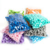 A collection of artificial foam rose flowers in various colors including blue, green, orange, pink, and gray.