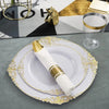 Elegant white and gold disposable dinnerware set with cutlery displayed on a gray cloth.