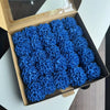 A box filled with bright blue lifelike foam roses for wedding and home décor.
