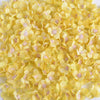 A pile of yellow silk artificial flower heads with pink accents for weddings and crafts