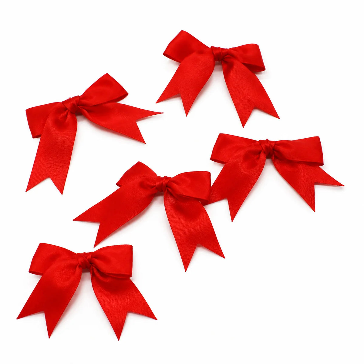 Three bright red satin ribbon bows arranged diagonally on a white background.