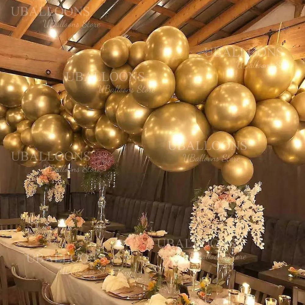 A golden balloon garland decoration is displayed indoors, featuring metallic chrome gold balloons and floral arrangements.