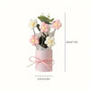 Handmade floral bouquet featuring pink and white flowers displayed in a pink cylindrical vase.