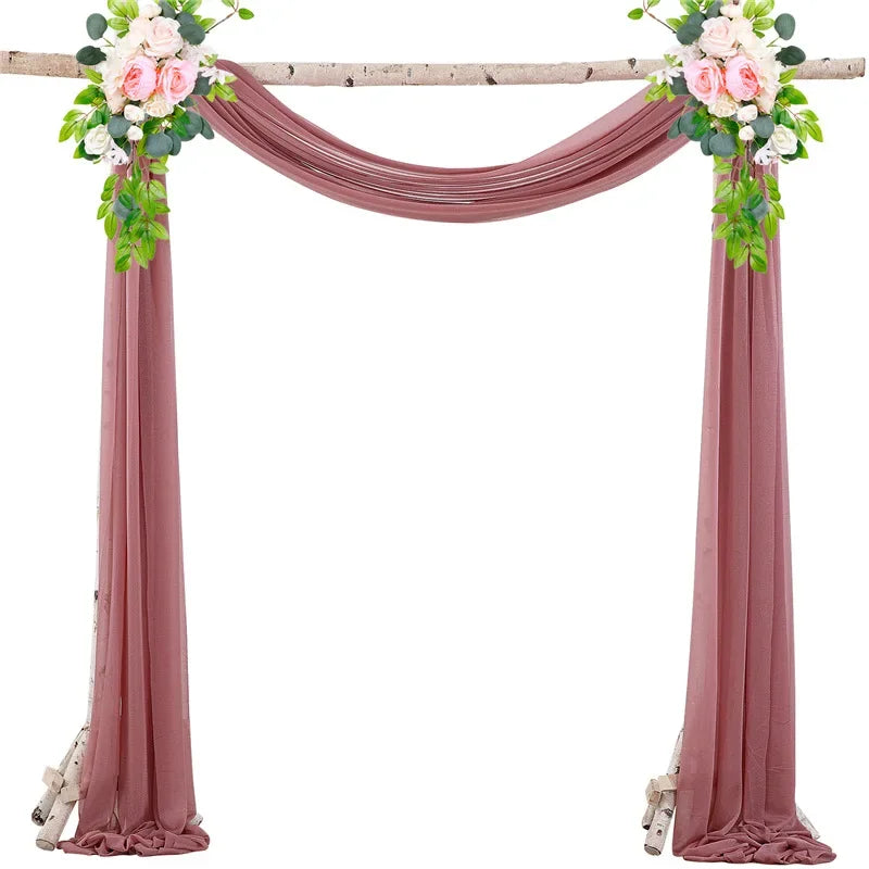 A set of two dusty rose chiffon fabric panels used for draping a wedding arch.