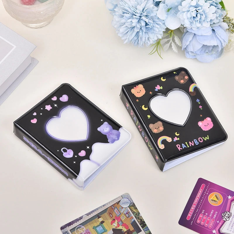 A black photo card album binder with a heart-shaped cutout and rainbow accents is displayed on a white surface.