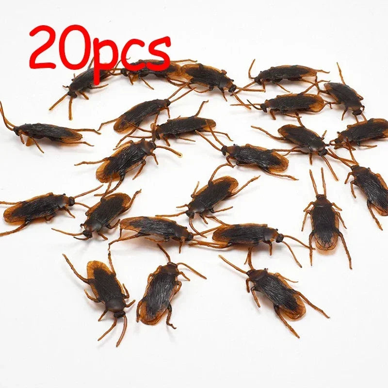 20 plastic cockroach gag toys scattered on a white background