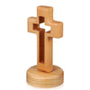 A wooden crucifix wall ornament with a cross shape mounted on a circular base.