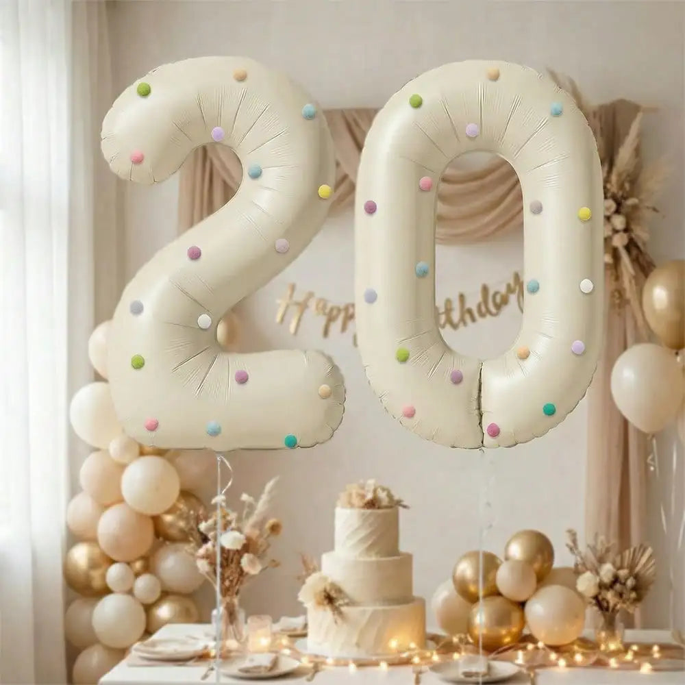 Two large milky white aluminum foil number balloons 2 and 0 decorated with gold and white balloons and floral arrangements