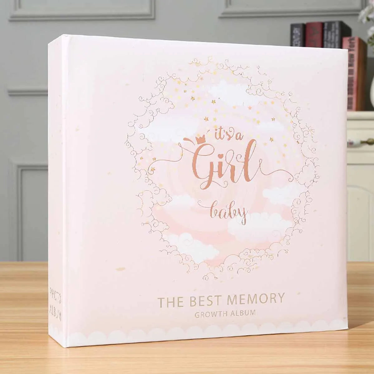 A pink photo travel album cover featuring a delicate floral wreath design and the text Its a Girl baby The Best Memory Growth