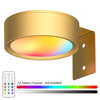A round LED picture light with a colored lens and magnetic mount, showing a spectrum of light colors.