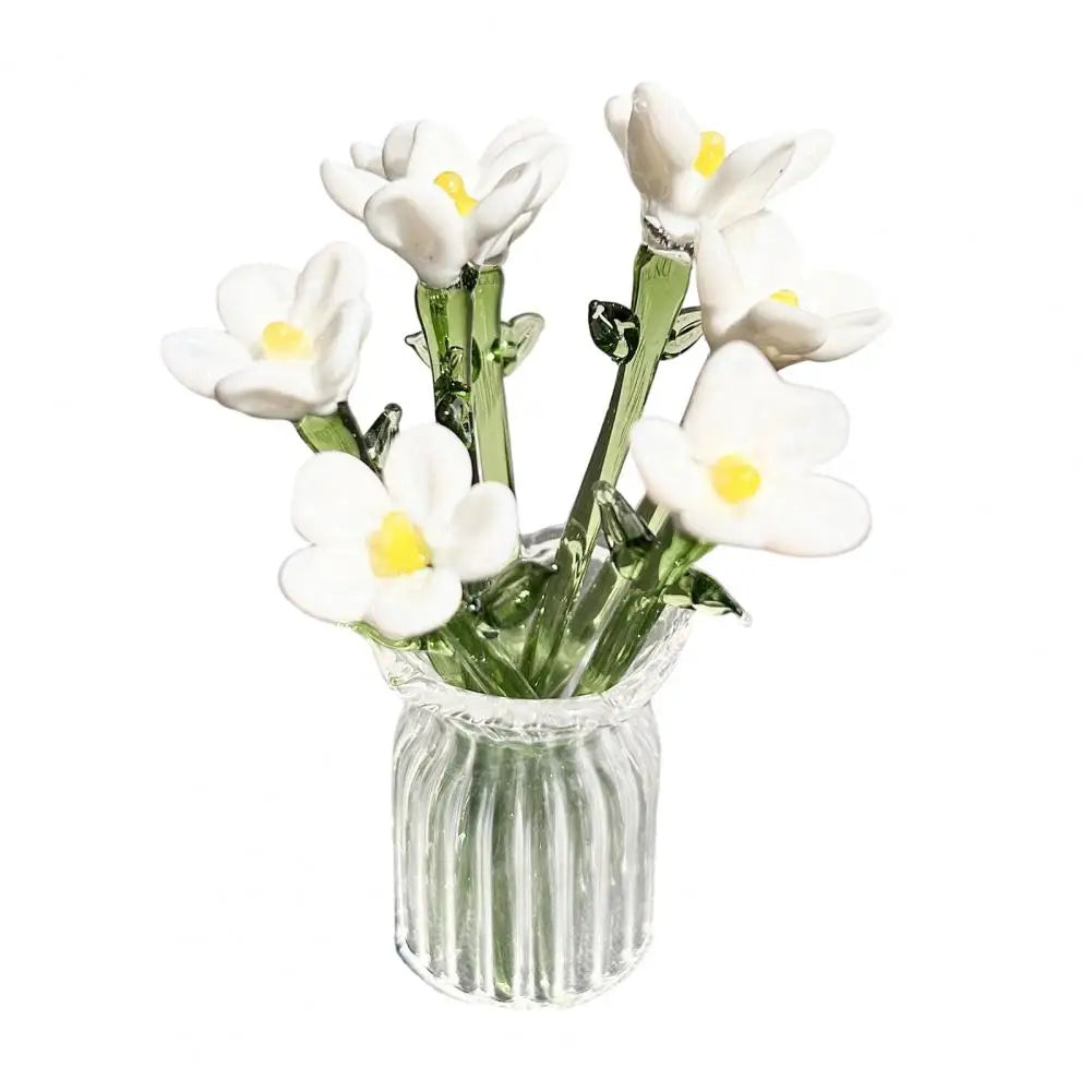 A bouquet of white and yellow flowers in a clear glass vase.