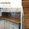 Close-up of a wooden countertop with visible wood grain texture and light brown color.