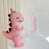 A pink dinosaur shaped balloon decoration and a clear number one balloon decoration.