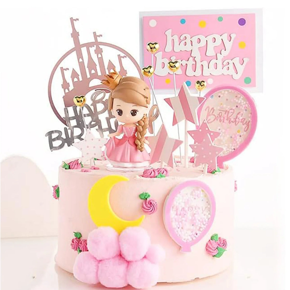 A pink birthday cake decorated with a castle topper, stars, and a yellow crescent moon, surrounded by pink floral accents.