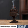 A square copper Pixiu incense burner with a lid and a figurine, emitting smoke.