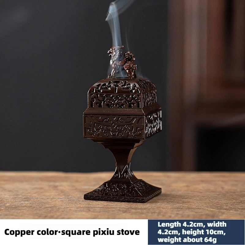 A square copper Pixiu incense burner with a lid and a figurine, emitting smoke.