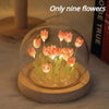 A glass cloche containing nine glowing orange tulips used as a handmade LED night light.